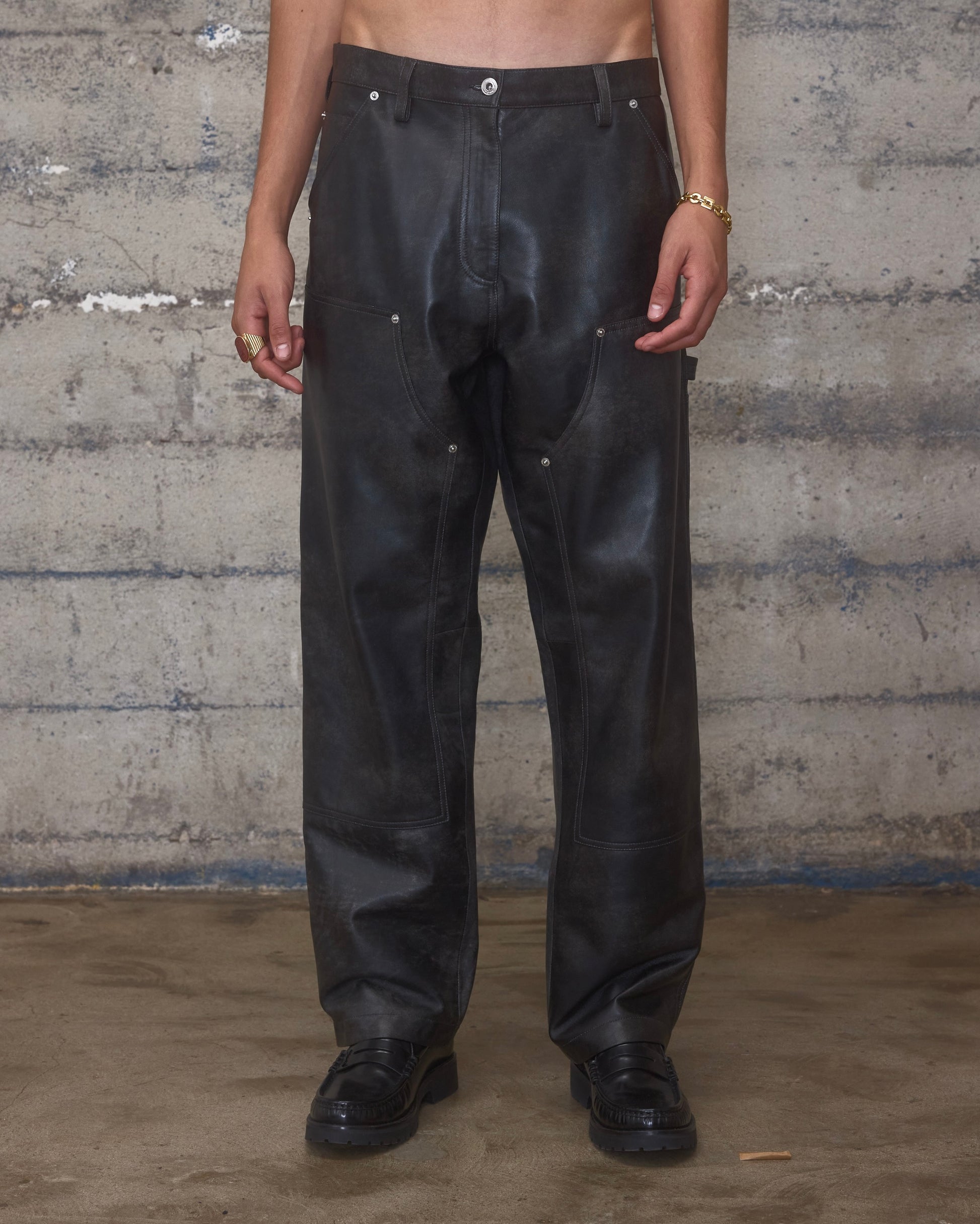 Person wearing black leather carpenter pants