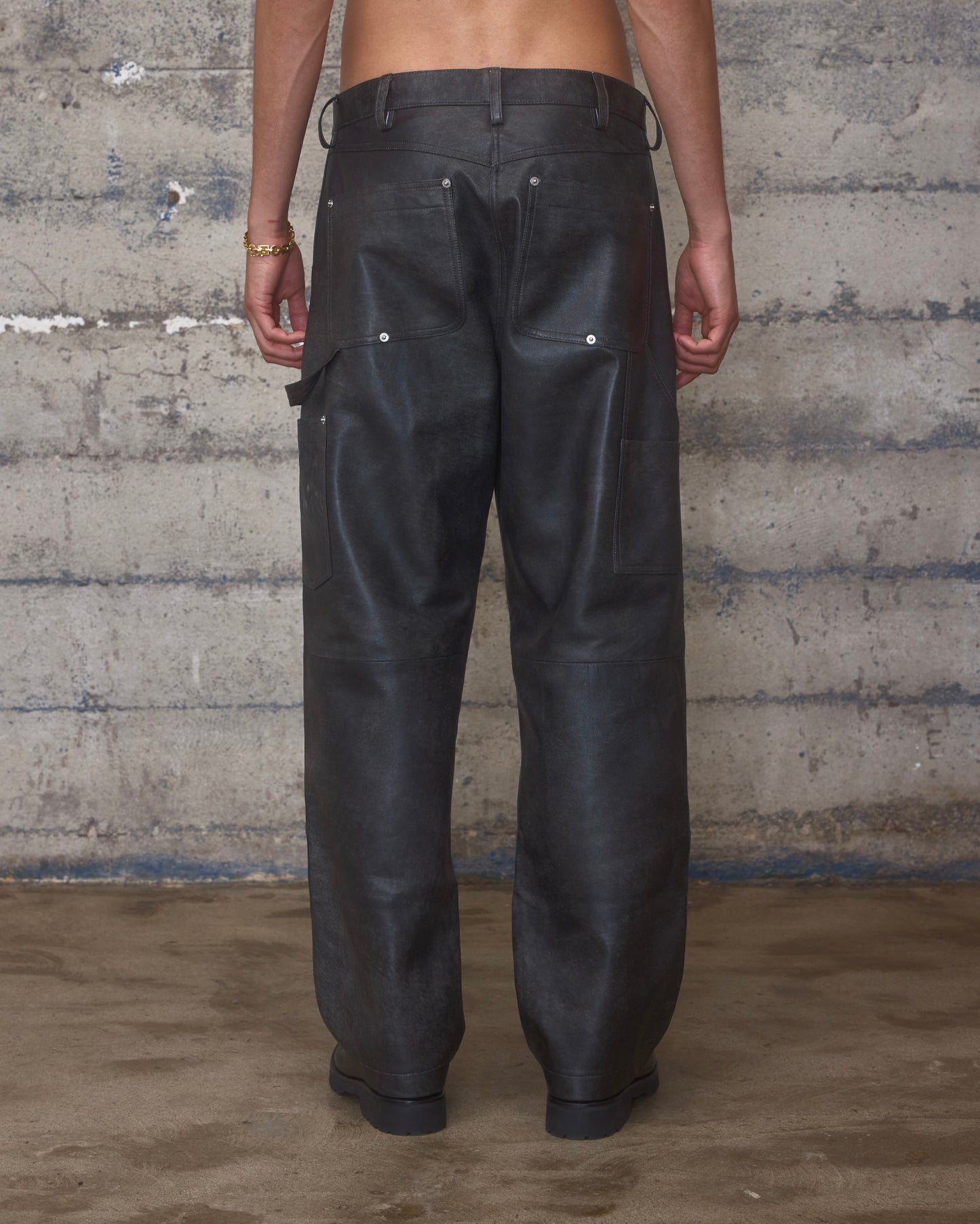 Person wearing black leather carpenter pants