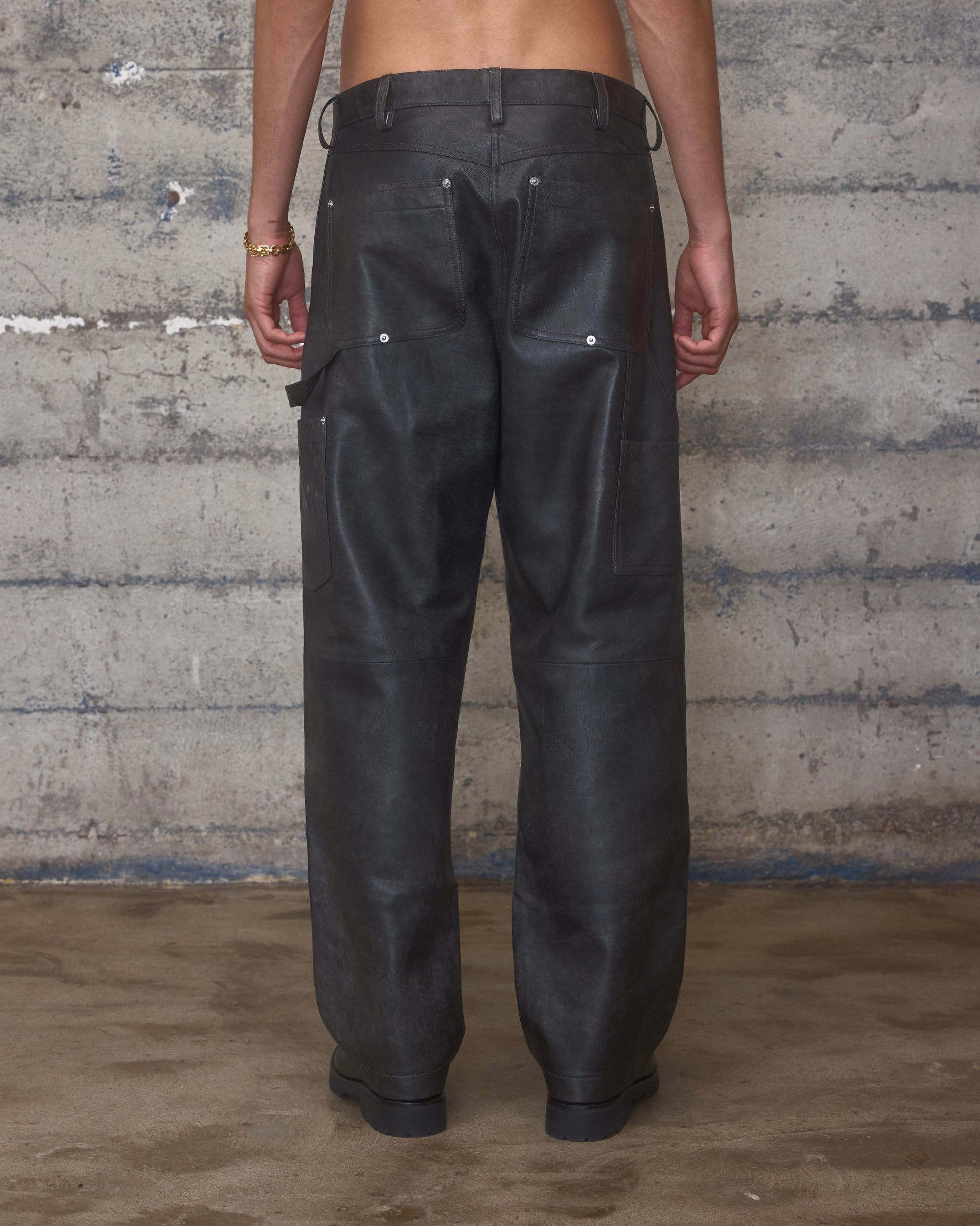 Person wearing black leather carpenter pants