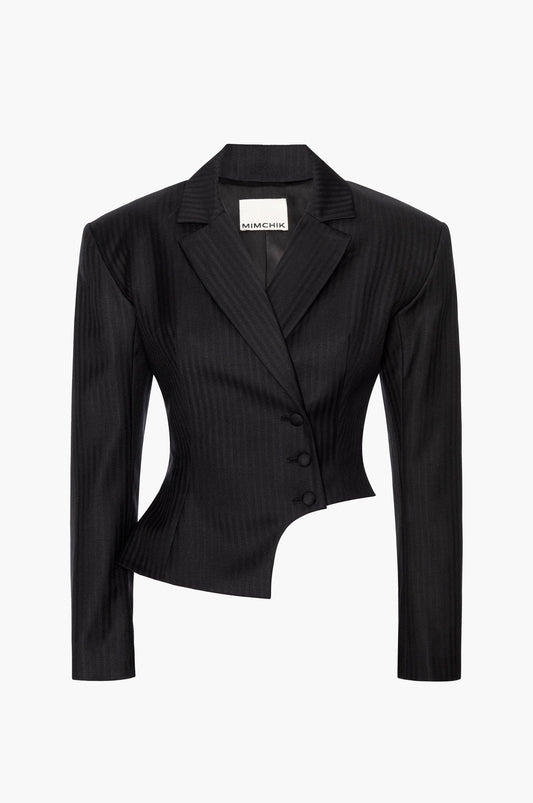A double-breasted, herringbone virgin wool blazer with bold shoulders, notched lapels, and a curved hip cutout on a white background