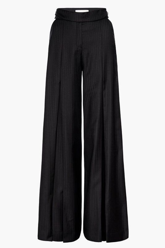 Pleated wide-leg trousers in black with cutouts at the hips and a buckle detail at the waistband on a white background