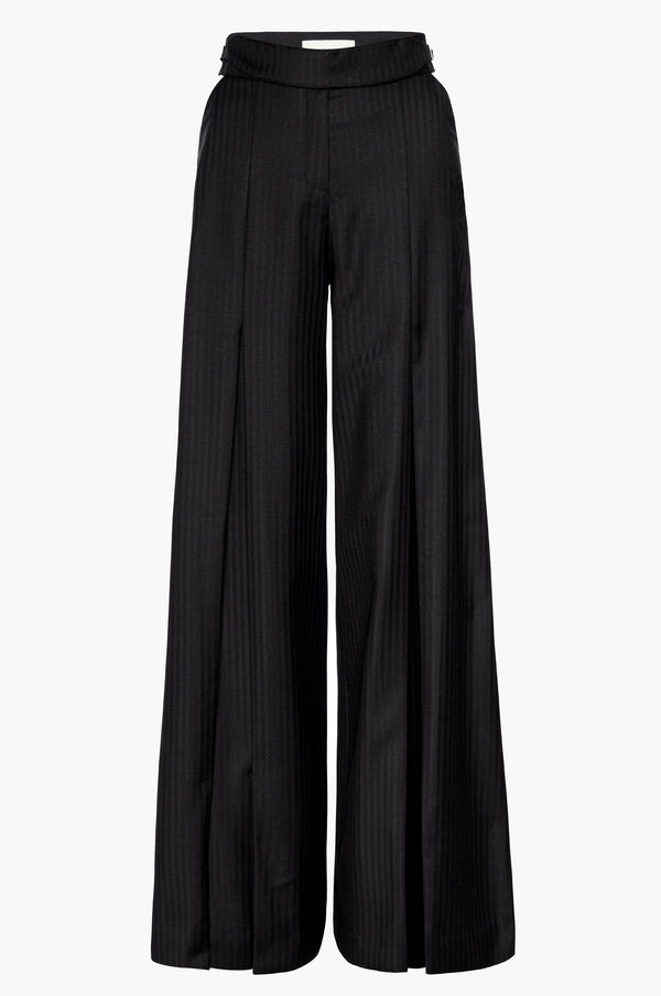 Pleated wide-leg trousers in black with cutouts at the hips and a buckle detail at the waistband on a white background