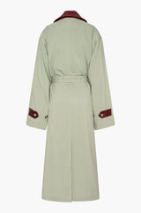 Seafoam green trench coat with a burgundy leather collar and cuffs on a white background