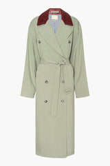 Seafoam green trench coat with a burgundy leather collar on a white background