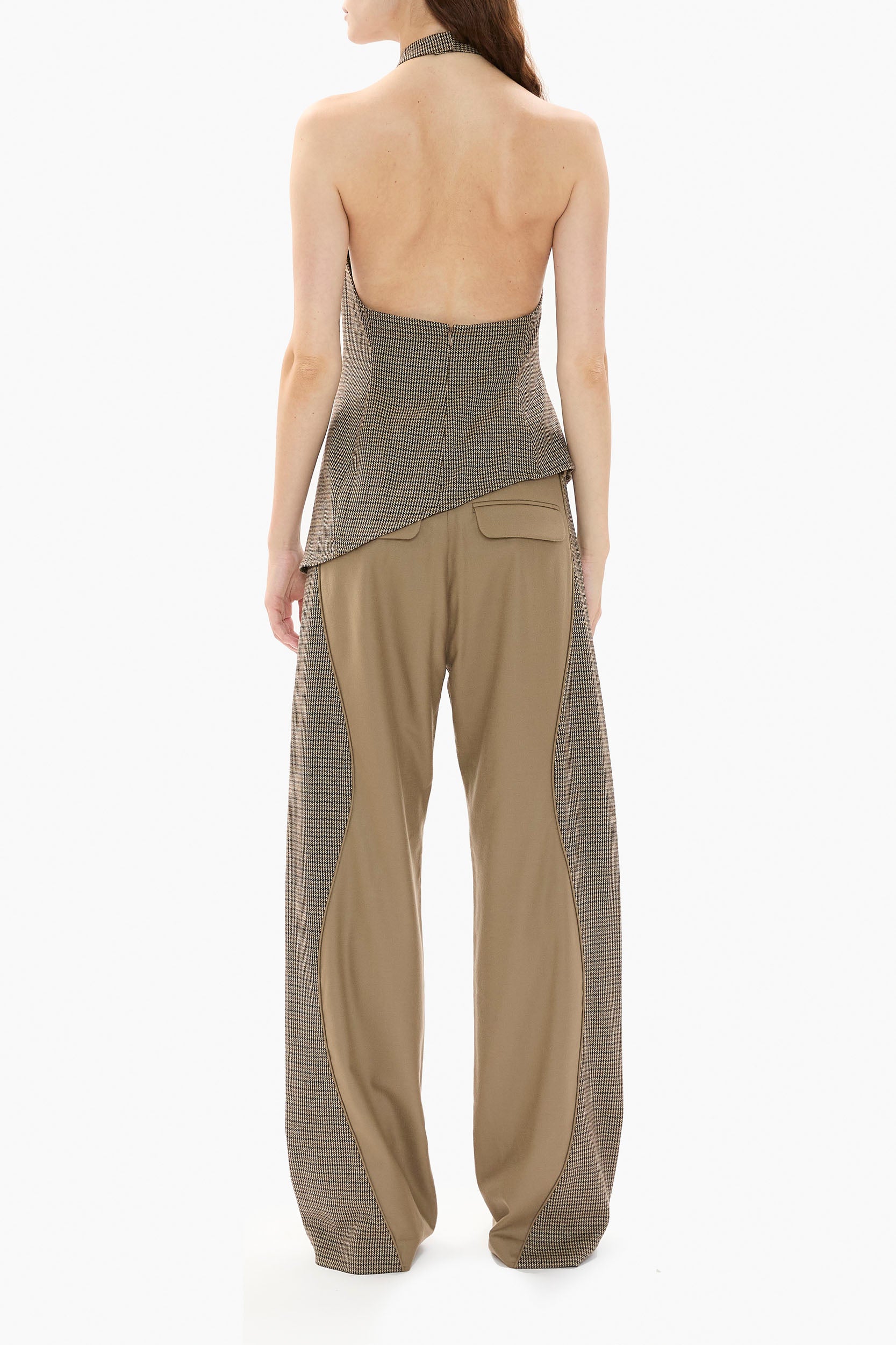 Woman wearing a houndstooth halter top and wide-leg pants with a houndstooth pattern on a white background