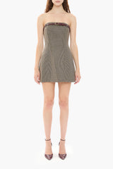 Woman wearing a strapless brown houndstooth dress on a white background