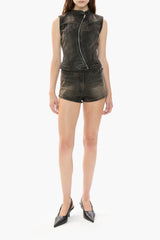 Person wearing a black denim vest and black denim shorts on a white background