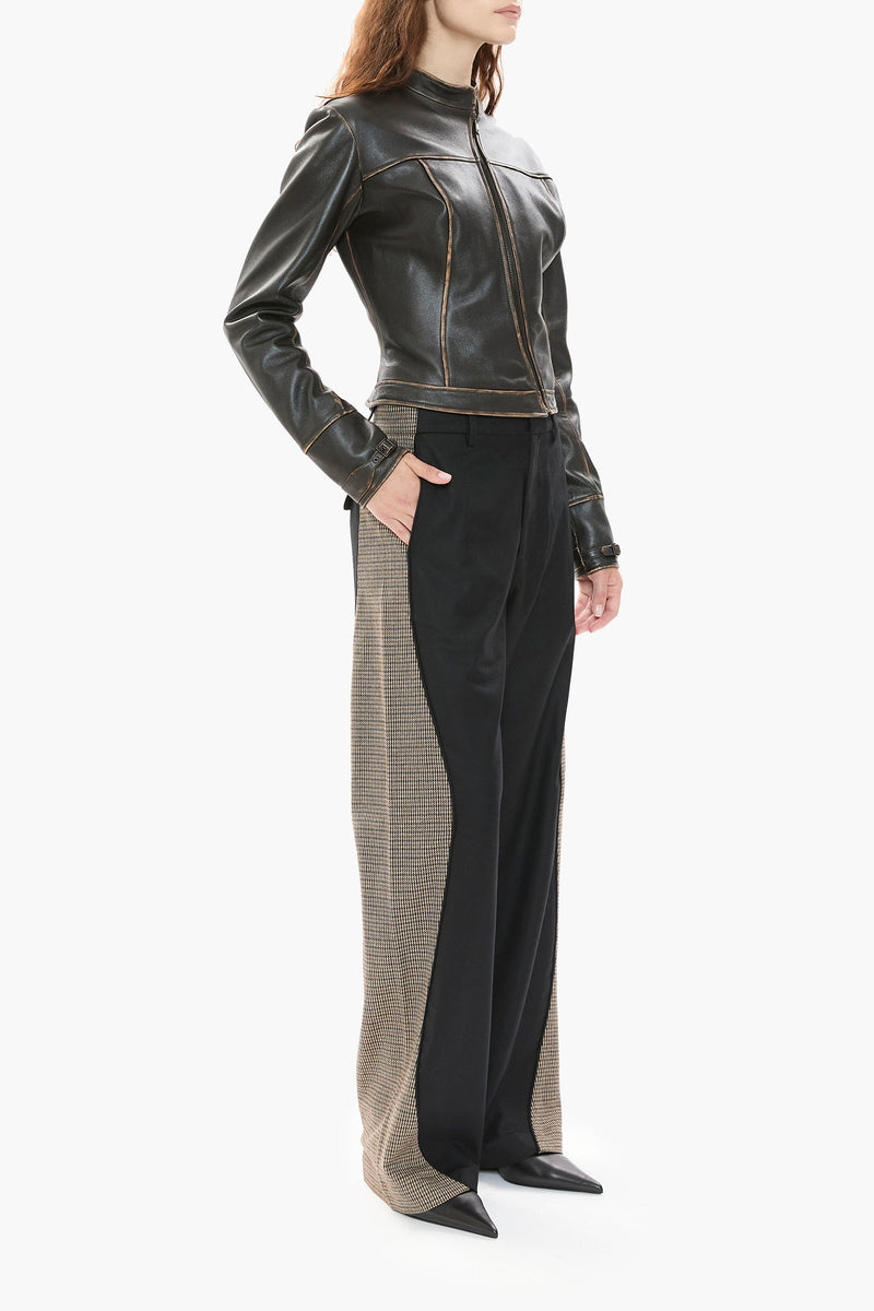 Person wearing a dark brown leather jacket and black pants on a white background