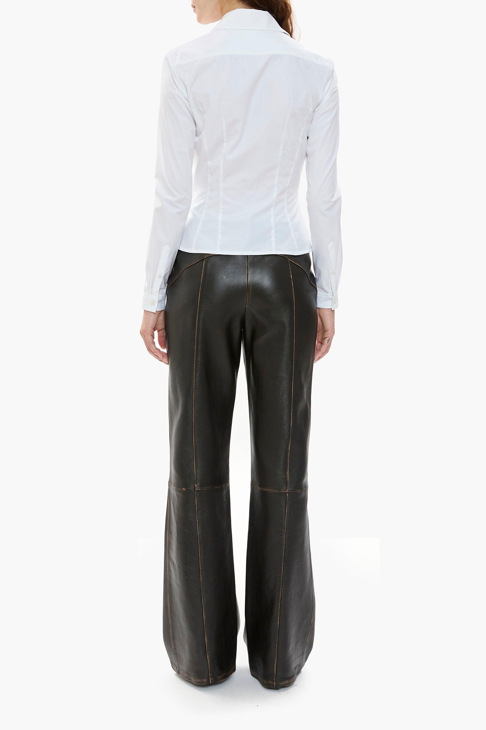 Person wearing a white shirt and black leather pants on a white background