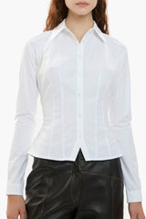 White button-down shirt worn by a person on a white background