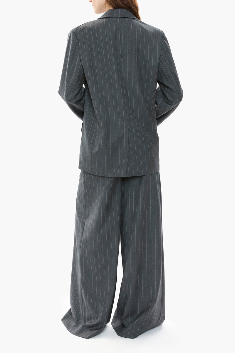 Person wearing a gray pinstripe suit on a white background
