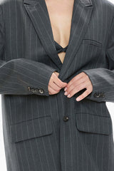 Gray pinstripe blazer with a deep neckline and buttons undone.
