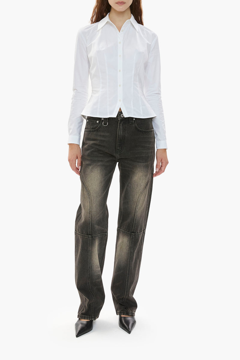 Person wearing a white shirt and distressed black wash jeans on a white background