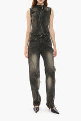 Person wearing a distressed black wash denim vest and jeans on a white background