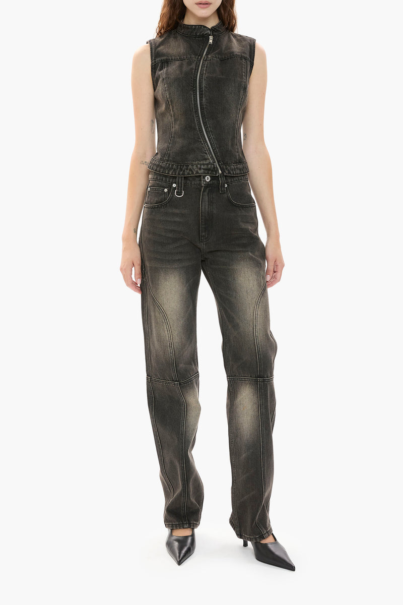 Person wearing a distressed black wash denim vest and jeans on a white background