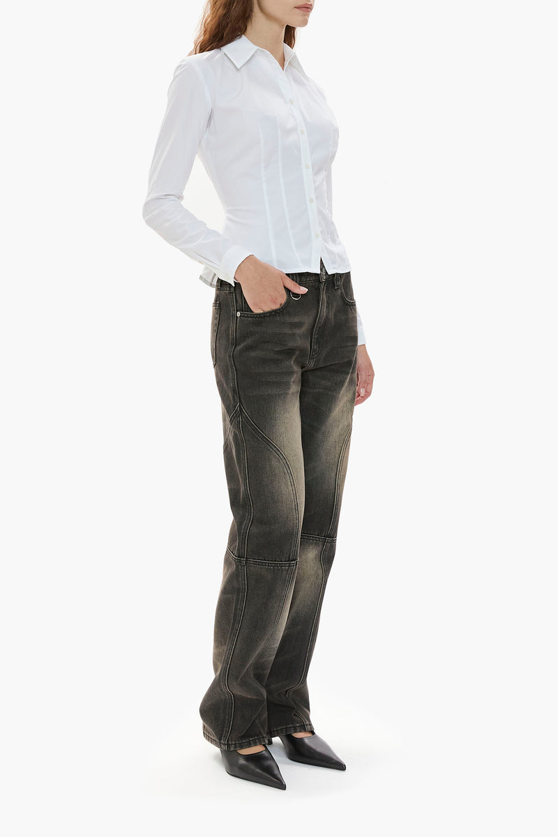 Person wearing a white shirt and distressed black wash jeans on a white background