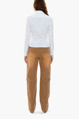 Person wearing a white shirt and brown canvas workwear-inspired pants on a white background