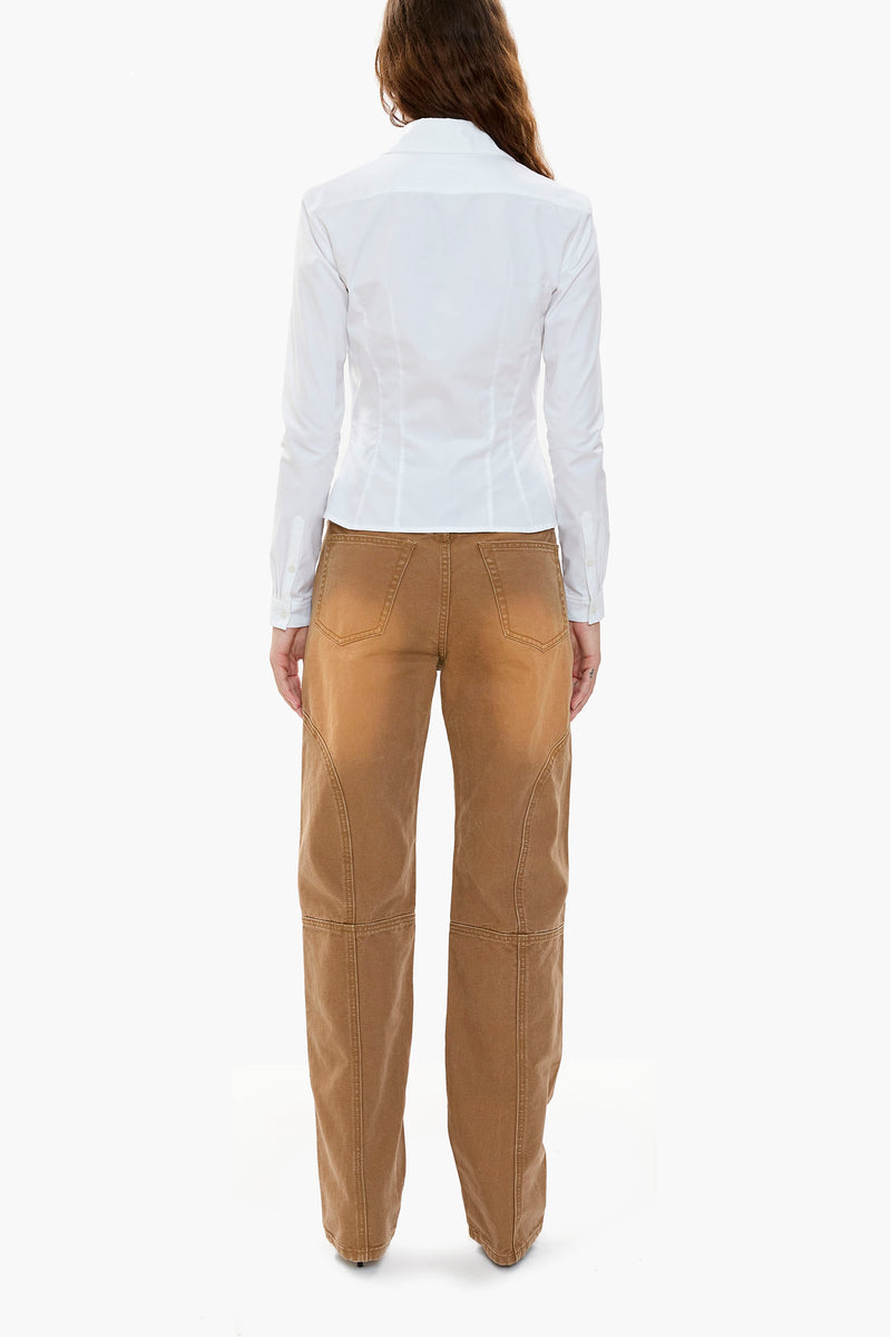 Person wearing a white shirt and brown canvas workwear-inspired pants on a white background