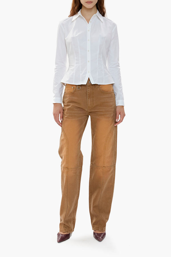 Person wearing a white shirt and brown canvas workwear-inspired pants on a white background