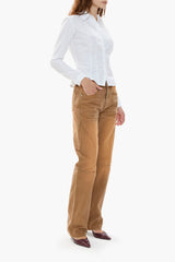 Woman wearing a white shirt and brown canvas workwear-inspired pants on a white background