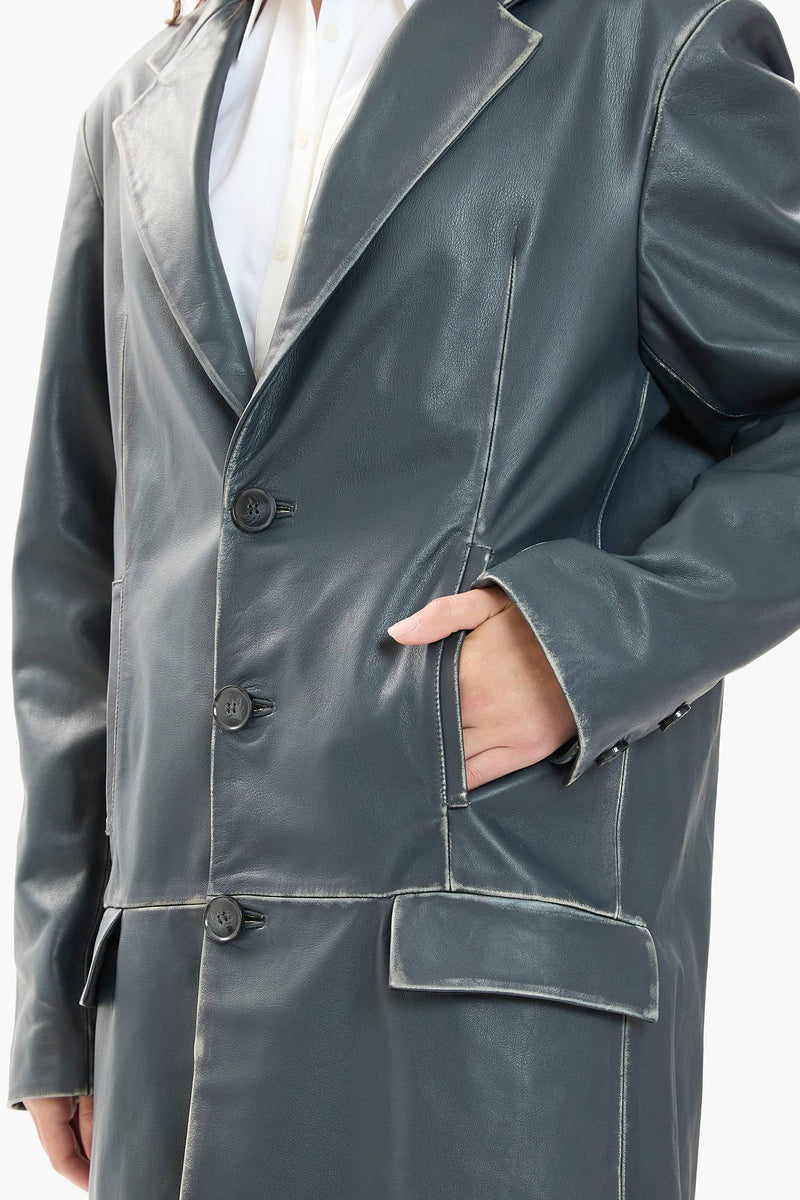 Dark blue leather coat worn by a person on a white background