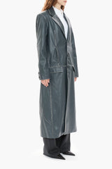 Person wearing a long dark blue leather coat on a white background
