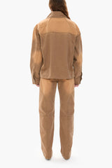 Person wearing a light brown canvas jacket and pants on a white background