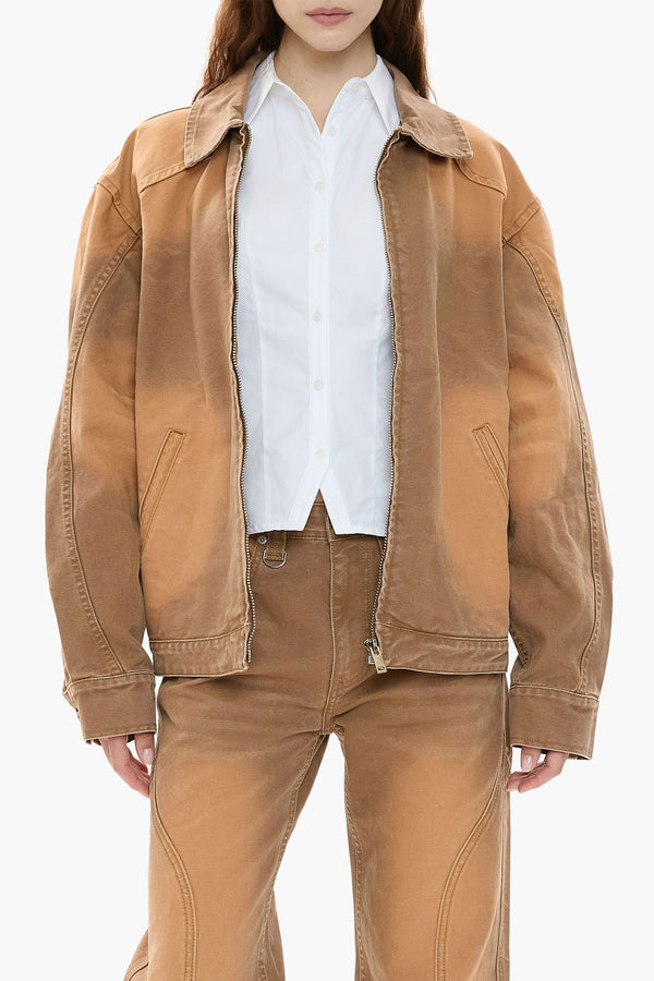 Person wearing a light brown canvas jacket and pants with a white shirt on a white background