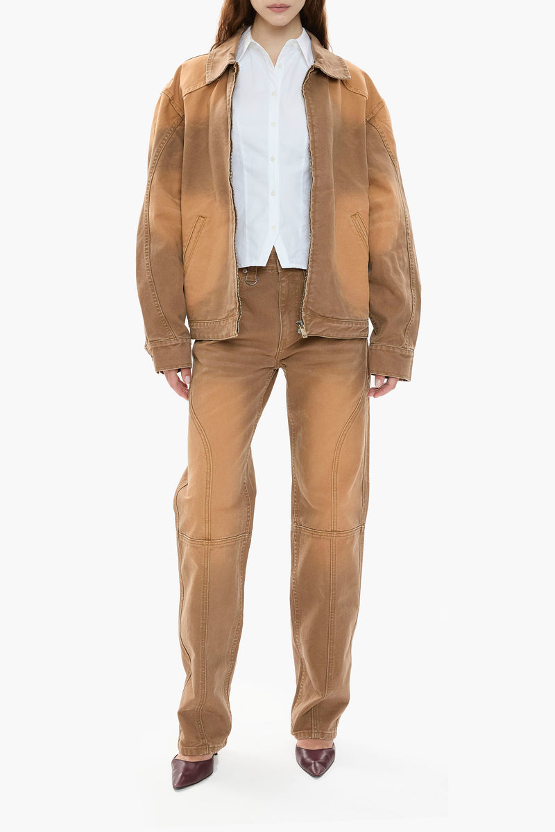 Person wearing a light brown canvas jacket and pants on a white background