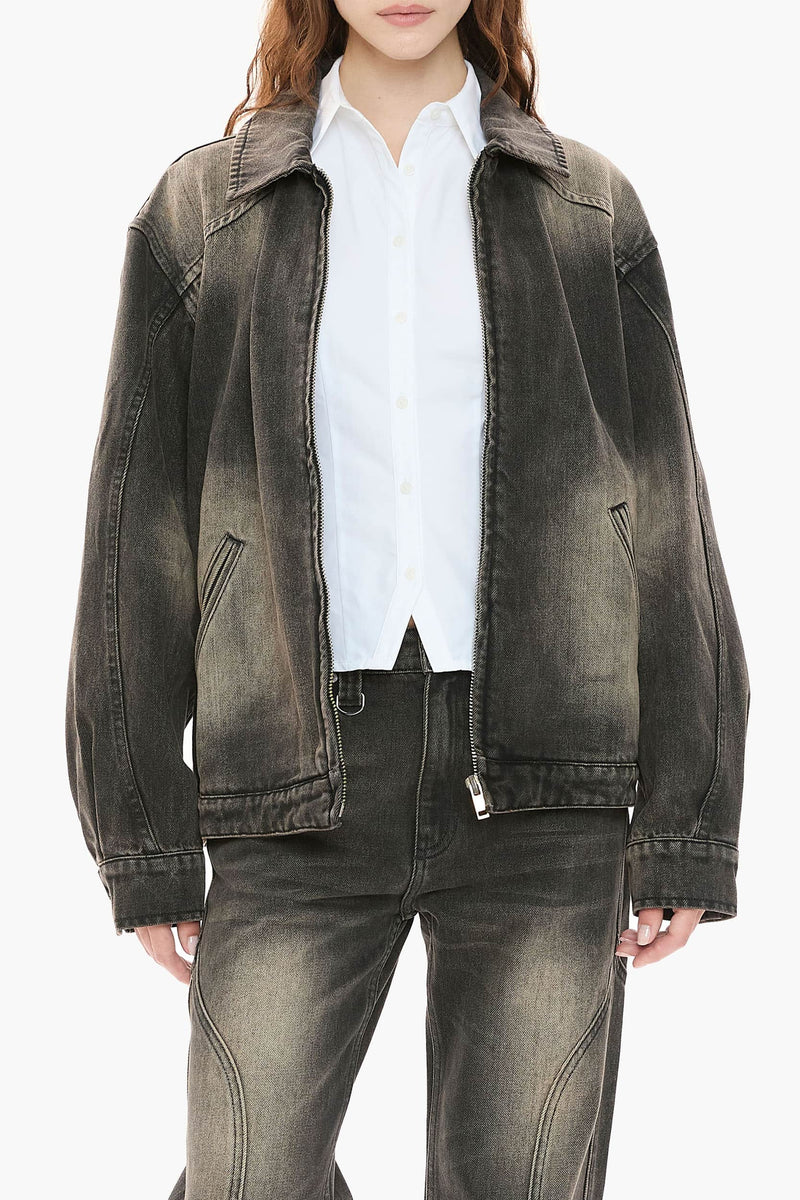Person wearing a black distressed denim jacket and jeans on a white background