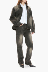 Person wearing a black distressed denim jacket, white shirt, and black jeans on a white background
